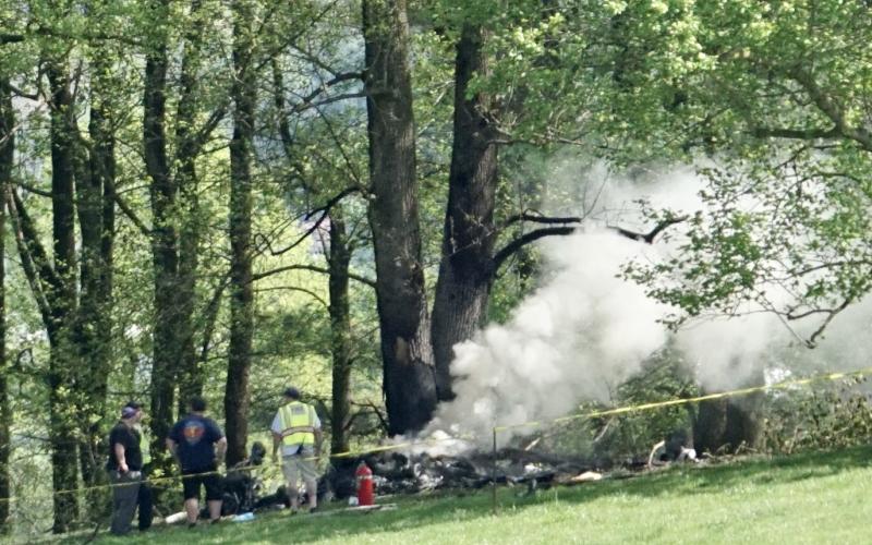 Emergency responders assemble beside the burning wreckage of a Velocity airplane that crashed shortly after takeoff from Western Carolina Regional Airport on Saturday morning.