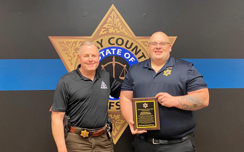 Sheriff Mark Buchanan presents Lieutenant Donovan Burke with a plaque of appreciation for his command of the detention center.
