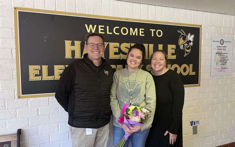Cayce Ledford has been named as Hayesville Elementary School Teacher of the Year. Ledford, in center, receives flowers from Clay Schools Superintendent Dale Cole and HES Principal Melissa Godfrey.