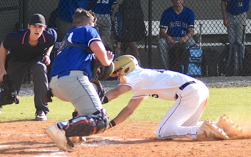 Gary Corsair • Clay County Progress Hayesville outfielder Logan Caldwell reaches for the plate as Hiwassee Dam catcher Trenten Beavers tries to glove the baseball.