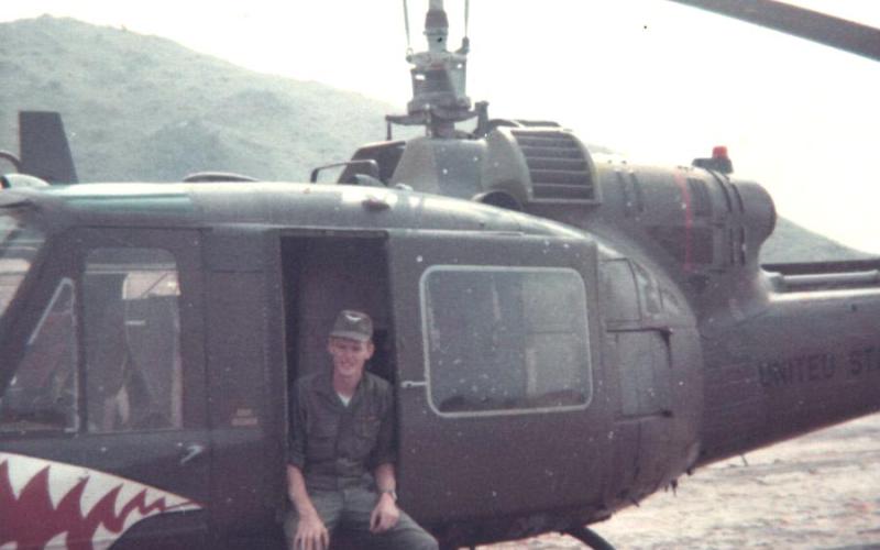 In Duc Pho, Sam Davis poses in a Shark gunship that is peppered with shrapnel from a mortar attack.