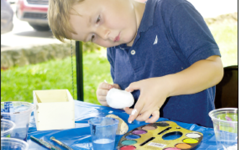 Becky Long • Clay County Progress Starlin Anderson, 6, focuses on his painted rock project at the children’s tent which offered free face painting and arts and crafts to children. Anderson ended up creating a cool rock with a snake and flower painted on it. The tent was hosted by the CCHAC.
