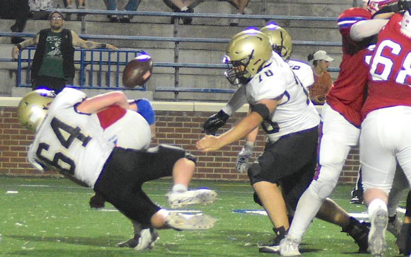 Gary Corsair • Clay County Progress Hayesville's Ethan McGuffie, No. 64, forces a fumble with a bone-jarring tackle as Yellow Jacket teammate Rayland Martinez, No. 78, lunges for the football as Tre Graves, No. 6, closes in.