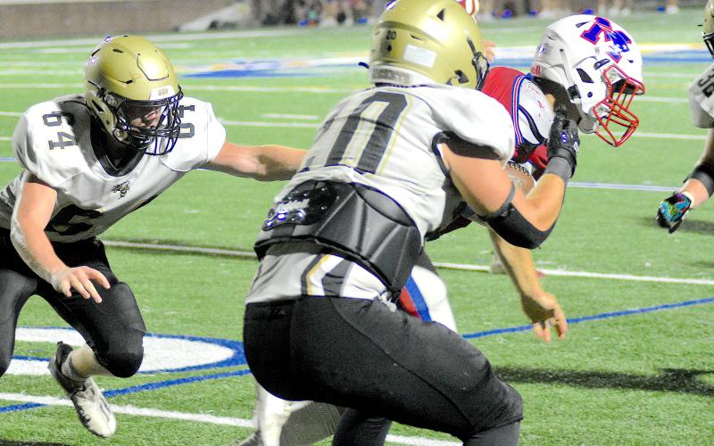 Gary Corsair • Clay County Progress Hayesville linebacker Taylor McClure, No. 20, puts the clamps on a Madison ball carrier as Yellow Jacket Ethan McGuffie, No. 64, prepares to ring the unfortunate player's bell.