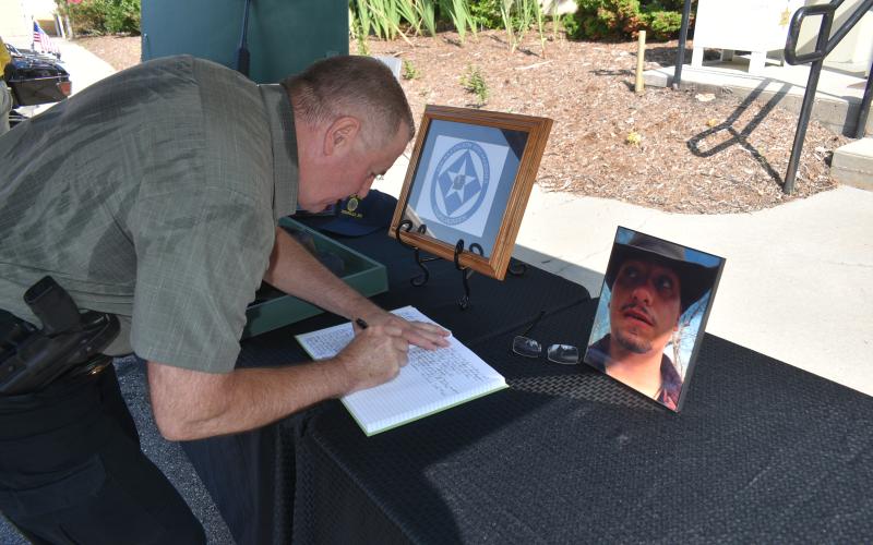 Becky Long • Clay County Progress Sheriff Mark Buchanan signs the memorial book after the July 27 service at the judicial center in Hayesville.