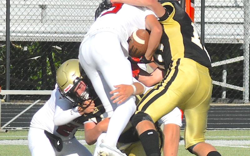 Gary Corsair • Clay County Progress Hayesville defenders Mason Buckner, No. 52, and Kaden Ledford, No. 10, high/low an Andrews ball carrier.