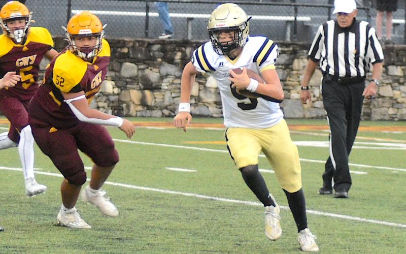 Gary Corsair • Clay County Progress Hayesville quarterback Lance Coker, No. 9, gallops around the end for a gain against Cherokee.