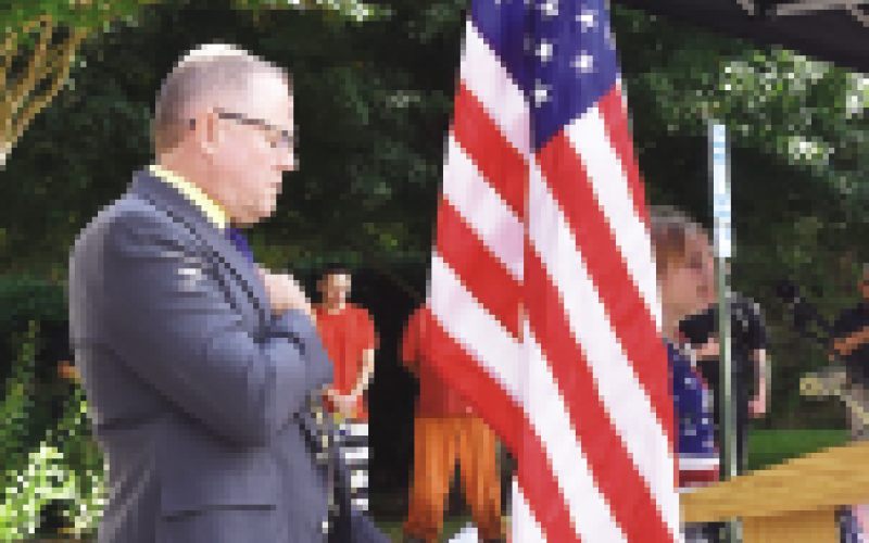 Becky Long • Clay County Progress Sheriff Mark Buchanan listens while Skylan Stillwell sings the National Anthem. Buchanan and his staff hosted the 9/11 ceremony marking 22 years since the fatal attacks on American soil.