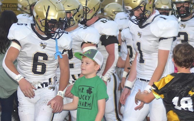 Gary Corsair • Clay County Progress Miracle boy Dallas Wilson walks with his friends Tre Graves, No. 6 and Peyton Mcgaha, No. 1, as the varsity Hayesville Yellow Jackets take the field Friday night.