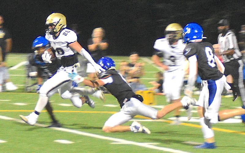 Gary Corsair • Clay County Progress Taylor McClure, No. 20, hurdles two defenders on the way to a 20-yard touchdown run after zipping through a hole opened by Hayesville's hard-working offensive line. McClure led the Yellow Jackets potent offense with 122 yards rushing.