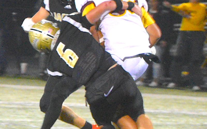 Gary Corsair • Clay County Progress Yellow Jackets Tre Graves, No. 6, and Isaac Chandler, No. 4, sandwich Cherokee workhorse J'ron Lineberry, No. 32.
