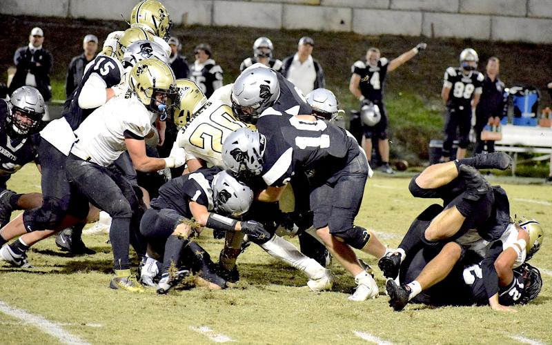 Photo by Jenny Collins Millsaps Hayesville's Taylor McClure, No. 20, fights to gain a first down on a crucial fourth-and-one carry. McClure's momentum appears to carry him to the desired destination, the short hash mark closest to the long line at the bottom of the photo, but officials ruled that McClure came up short and awarded the ball to Robbinsville.