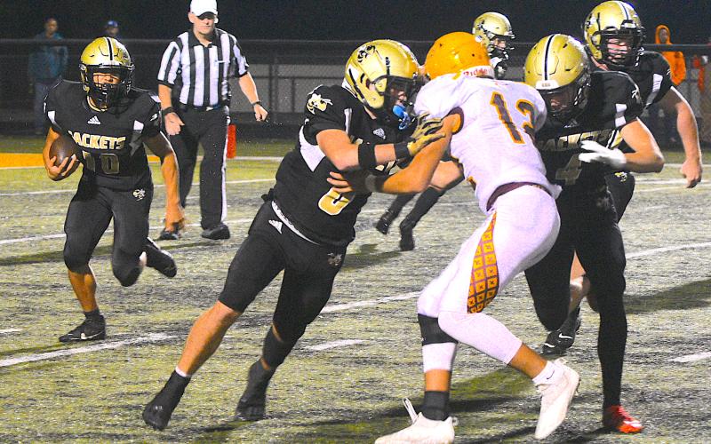 Gary Corsair • Clay County Progress Hayesville's Cole Vining, No. 10, scoots around the end as Tre Graves, No. 6, and Isaac Chandler, No. 4, double team a Brave.