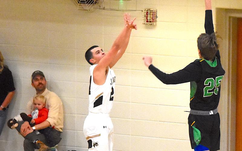 Gary Corsair • Clay County Progress Hayesville's Riley Rogers, No. 24, lofts a three-point attempt over a Bulldog defender. Rogers finished with 10 points off the bench.
