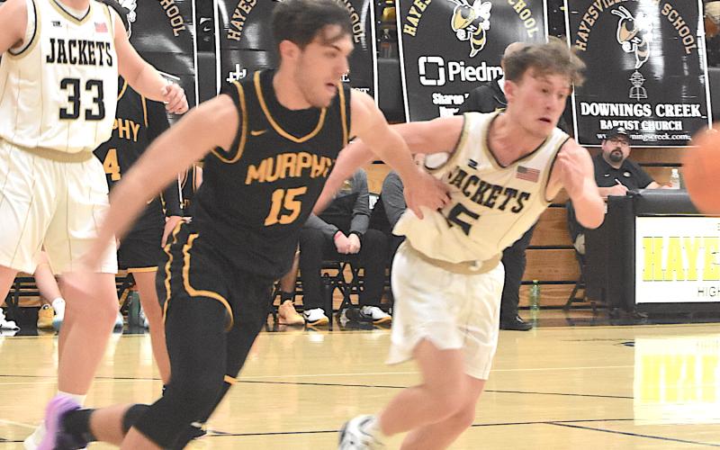 Landon Hughes, No. 15, fends off a Bulldog as they race to retrieve the basketball.