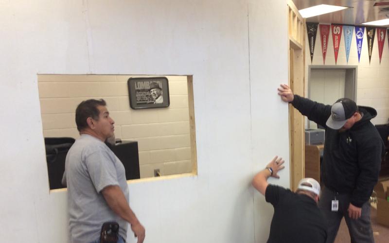Adam Sanchez, Chris Lange and Steve Lyvers work on the underground school store front.