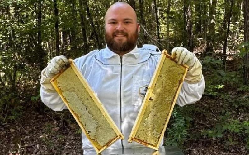 Branson Worley with his beehives carrying on a family tradition and his dream.