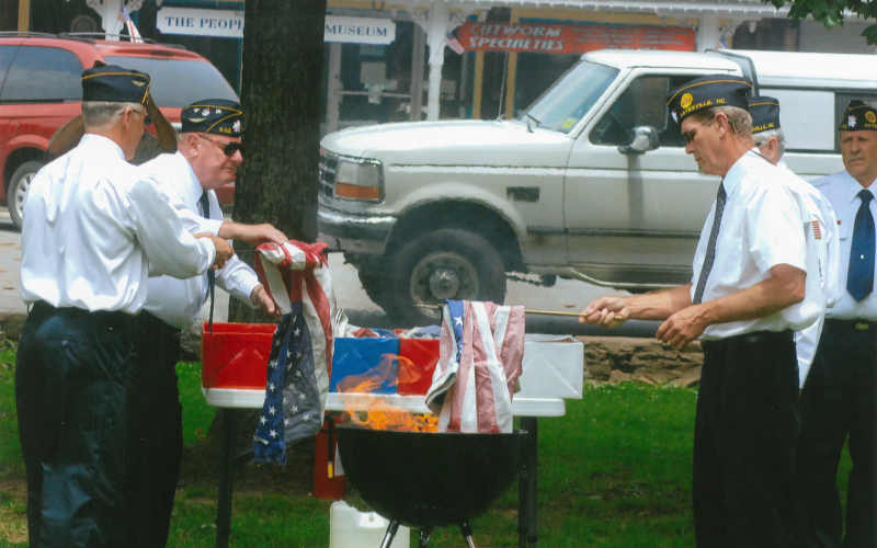 Veterans dispose of the American flag in a previous flag retirement service on the Hayesville town square, among the participants are from left, Tommy Hooper, Jack Greve and Carl Maxwell