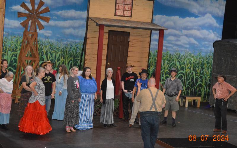 Photo by Pam Roman The “Oklahoma!” cast and ensemble are, from left, by windmill, Teresa Lemaire, Leslie Richardson, Leta Reeves, Mikey Lindsey and Janice Lessard; front row, Natalie Schaible, Hope Ledford, Carli LeJeune, Patty Carreau, Alex Giles, Joe Zang, Harrison Keely and Paul Keely; back to camera, Cameron LeJeune, warm up.