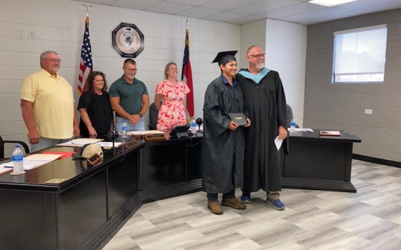 Marcia Barnes • Clay County Progress Board members Danny Jones, Kelly Crawford, Jason Shook and Superintendent Melissa Godfrey recognize Santiago Renteria Mendoza as he receives his diploma from Hayesville High School Principal Stacey Overlin.