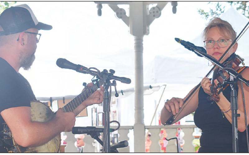Becky Long • Clay County Progress Lindsey Liden and sister Emolyn Liden tune up the Festival on the Square Sunday with unique, old-time music which is a family tradition for them. The festival is sponsored by Clay County Historical and Arts Council. It drew a large crowd on Saturday and was a little more subdued on Sunday which is usually the case. Vendors reported good sales and attendees reported delicious food and by all accounts everyone was grateful for the sunny, albeit hot weather.