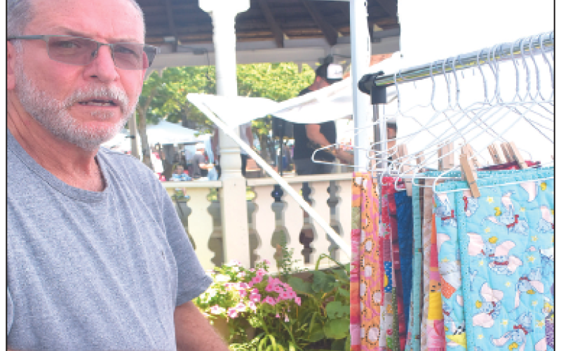 Tommy Burch mans the booth of quilts made by his wife Janis as a ministry to children. Janis appliques a heart on the back corners that say, “Jesus loves me,” which she said is the purpose of the quilts. She quotes, ”Let the little children come to me and do not hinder them, for the Kingdom of Heaven belongs to such as these,” Matthew 19:14.