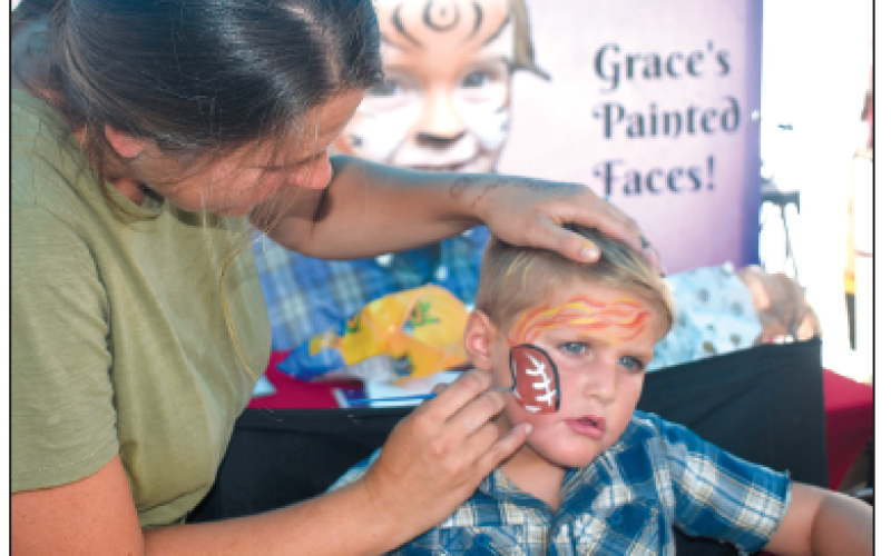 Jacob Taylor, 4, remains still while he gets his favorite pastime, a football, painted on his face at Grace’s Painted Faces booth at the Festival on the Square. There were two booths for face painting along with the ever popular Fairy Hair and homemade wooden toys and gadgets for kids. There were a multitude of artists on hand with work to fit all age ranges.