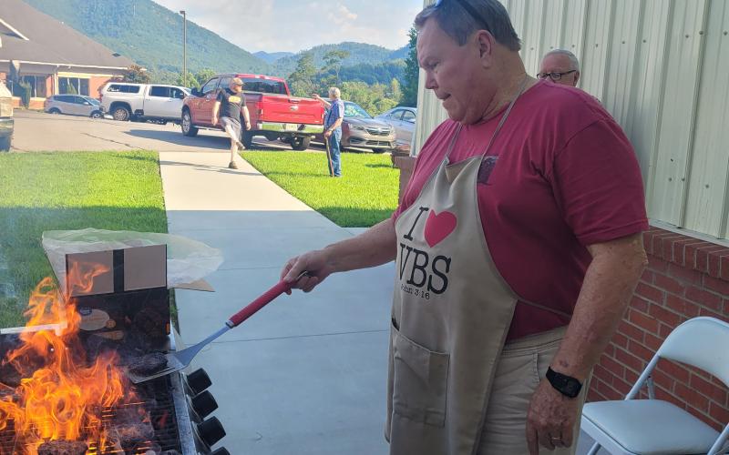 Tim Thompson fires up grill, cooking hamburgers for the first responders’ night.