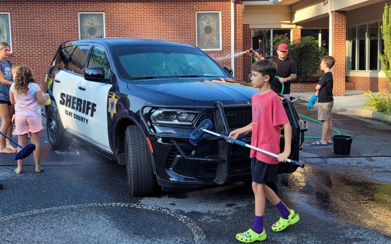 Mount Pleasant Baptist Church students, from left, Jameson Dawson, Sydney Greenstone, Charla Segars, Martin Ledford, Student Pastor Eric Segars and Jones Pressley wash a Clay County Deputy’s car.