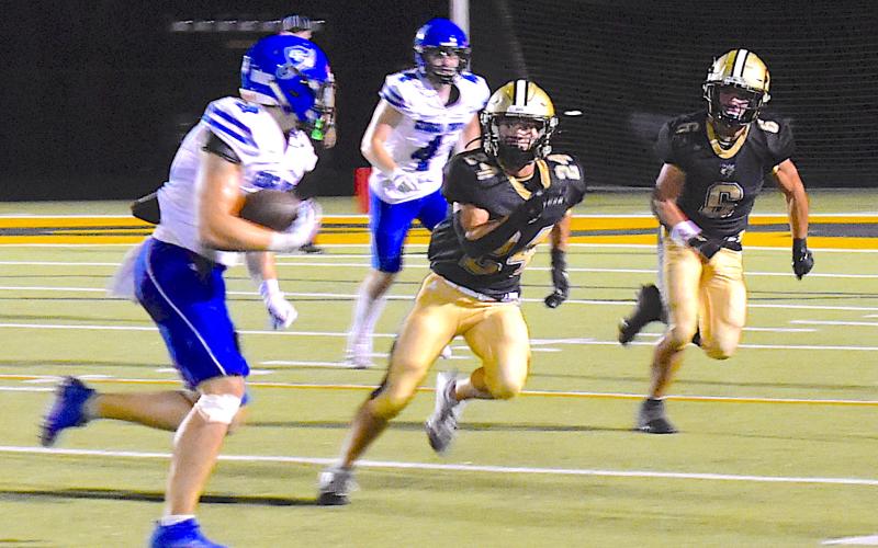 Gary Corsair • Clay County Progress Hayesville defenders Mike Mauney, No. 24, and Tre Graves, No. 6, move into a close off an end run.