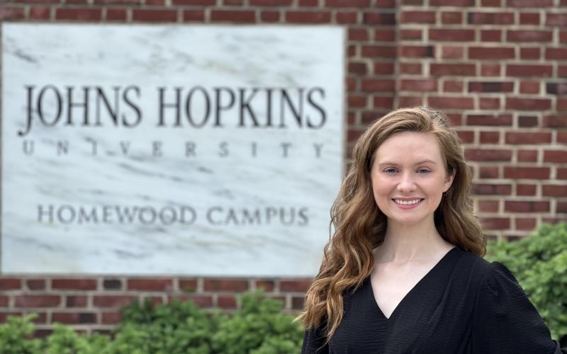 Photo by Connor Vernachio A jubilant Brianna Ross stands at the entrance of the Johns Hopkins University campus in Baltimore after receiving a Masters Degree in May 2024.