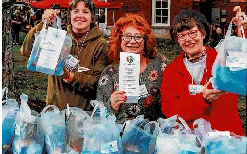 From left, HHI volunteers Misti Muscat, Lynne Maniotes and Wendy Slaton provided attendees packets at a previous Steins &amp; Wine event. The bags are available at the entry gate with information about vendors and supporters.