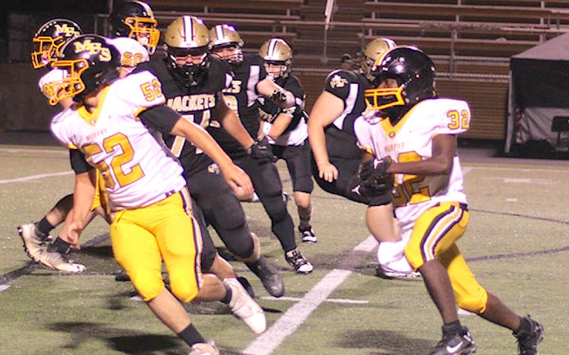 Photo courtesy Cherokee Scout Hayesville lineman Rayland Martinez, No. 74, leads the defensive line in pursuit of Murphy's Way Herron, No. 32.