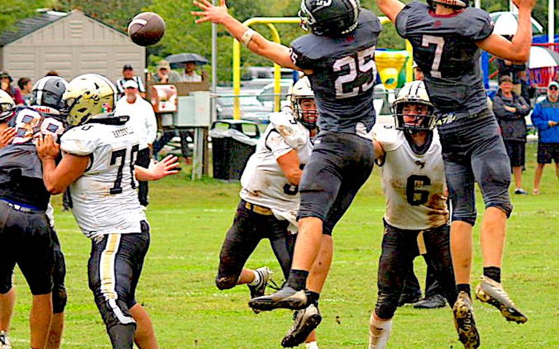 Gary Corsair • Clay County Progress Tate Roberts, No. 5, threads the needle as Rayland Martinez, No. 78, and Tre Graves, No. 6, provide protection from leaping Lions.
