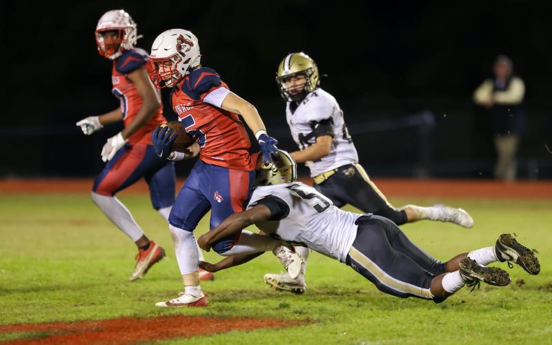 Photo by Marc Lancaster Will Brown, No. 56, takes down Union Academy's Kaden Crooke, No. 5, as Yellow Jacket Michael Mauney, No. 24, closes in to help.