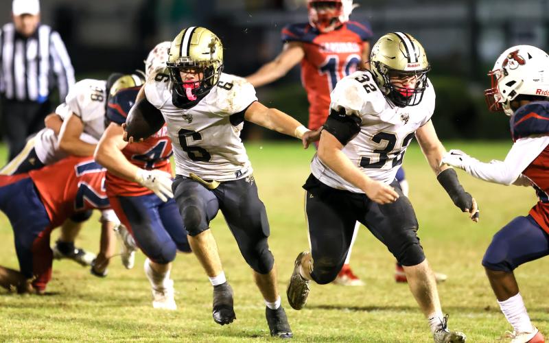 Photo by Marc Lancaster Tre Graves, No. 6, follows Dawson Devane, No. 32, through a huge hole.