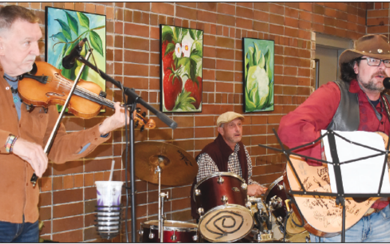 Becky Long • Clay County Progress Attendees to Saturday’s holiday luncheon enjoyed the southern sounds of Big Ol Southern Grin featuring, from left, John Andrews on fi ddle, Joey Buckner on drums and Josh McConnell on guitar. The band plays local private and public venues. They can be reached at 828-342-8444. They describe their repertoire as outlaw country. The band’s name was born from a lyric in the Lynyrd Skynyrd hit “Workin’ for the MCA.”