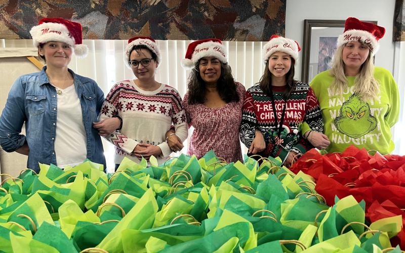 Deby Jo Ferguson • Clay County Progress REACH of Clay County contributes Christmas packages to the Clay County Care Center for the residents. According to Executive Director for REACH Judith Alvarado, “Christmas is most truly Christmas when we celebrate it by giving the light of love to those who need it most.” From left, Sommer Rector and Ashley Harris victim advocate and Judith Alvarado at REACH; Michaela Hildebrand recreational therapist and Beth Stroud, receptionist at Clay County Care Center.