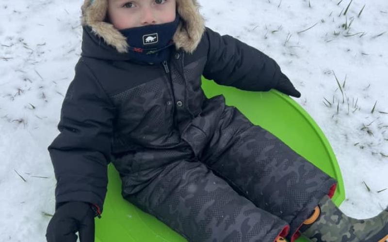Swayer Cook enjoys his first snow while  seeing just how far he can on on the sled