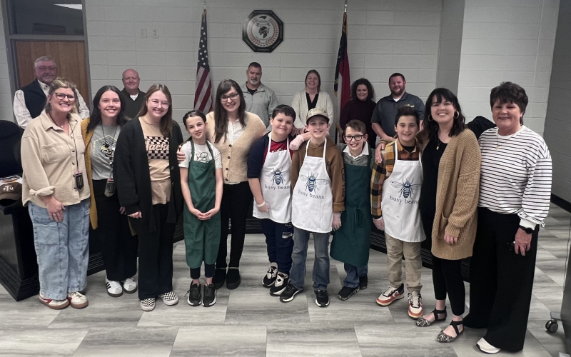 Angel Owens • Clay County Progress Staff and students of the Hayesville Elementary School Busy Beans Program, front, from left, Emily Hensley, Krysta English, Mily Ledford, Rejonie Gailley, Carly Anderson, Gabe Garcia, Bentley Smith, Gabe Canup, River Denton, Cayce Ledford and Kay Sprinkles, served drinks to the Clay County Board of Education, back, from left, Danny Jones, Robert Caldwell, Chairman Jason Shook, Superintendent Melissa Godfrey, Kelly Crawford and Josh Ashe Monday’s meeting.