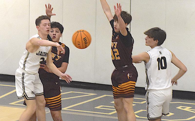 Gary Corsair • Clay County Progress Hayesville's Micah Moss, No. 2, kicks the ball out to a teammate for a 3-point attempt as Daemien Soto, No, 10, fights for position.