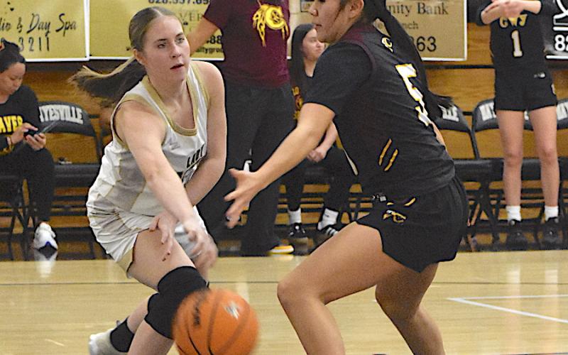 Gary Corsair • Clay County Progress Hayesville's Briley Clampitt, No. 14, shovels a bounce pass to Mallory Peck under the Cherokee basket.
