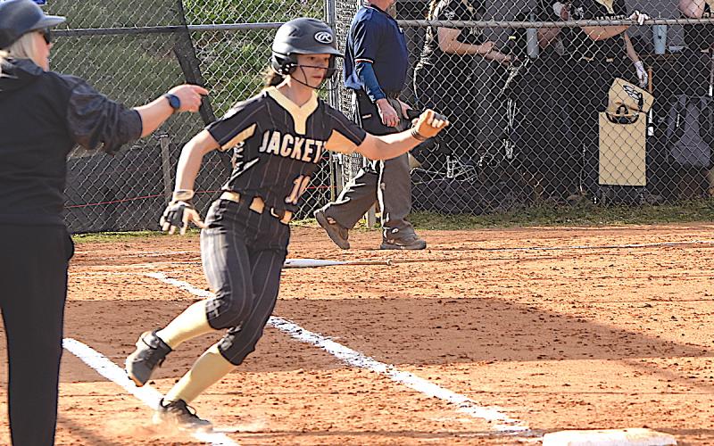 Gary Corsair • Clay County Progress Hayesville Assistant Coach Jessica McClure waves Micalynn McClure on to extra bases after the fabulous freshman slammed a pitch into the outfield.