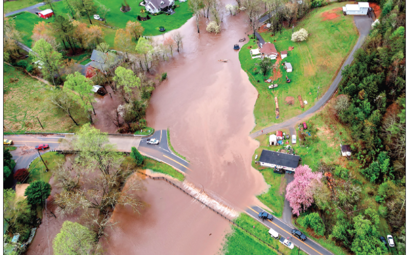 Ron Wallace Photo The overflowing creek affected residents traveling and living in several areas in Clay County including the River Oaks section along Tusquittee Creek. In the photo is Bailey Acres on the right side of the Creek and where the red car is entering, the new bridge on Fires Creek. The white car is driving toward Julia Buckner road.