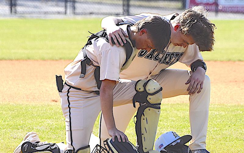 Gary Corsair • Clay County Progress Hayesville battery Chance Hughes and Jackson Sellers pray prior to the beginning of a recent game.