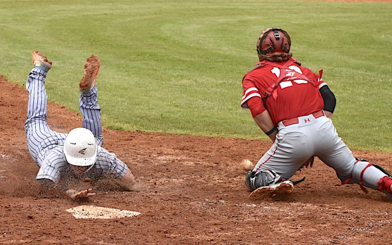 Gary Corsair • Clay County Progress Hayesville's Dawson Devane does a Peter Rose slide into home ahead of the throw during the Yellow Jackets comeback against Franklin.