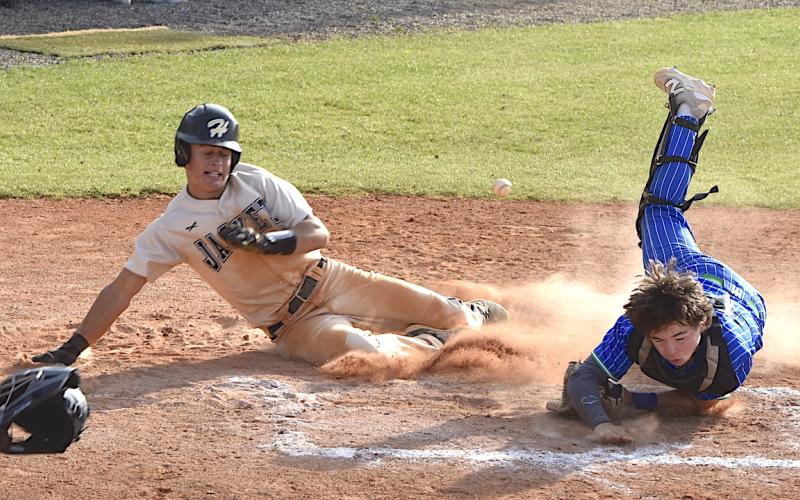 Gary Corsair • Clay County Progress Tate Roberts bowls over the Mountain Island catcher to score the tying run.