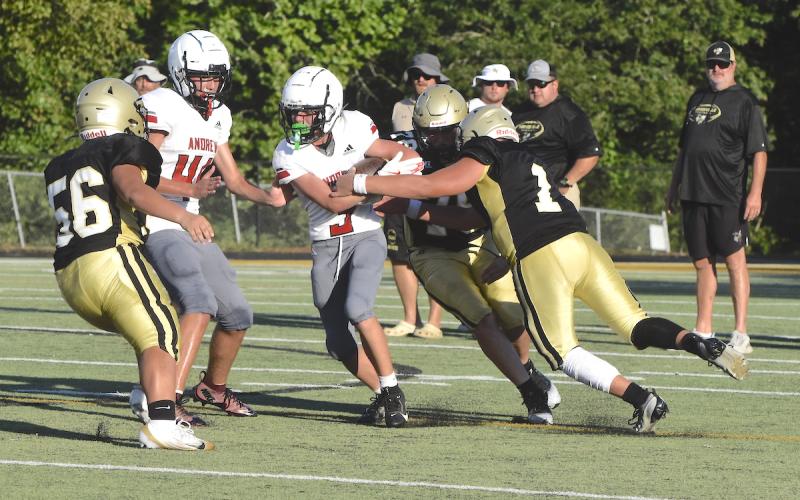 Gary Corsair • Clay County Progress Luke Buckner, No. 1, tries to strip the ball from an Andrews Wildcat as Yellow Jackets Jake Frentz, No. 78, and A.J. Austin, No. 56, move in for the tackle during a JV scrimmage in Hayesville.