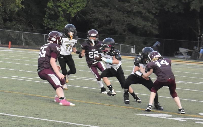 Callie Long • Clay County Progress No. 14 Avery Barter takes off with the ball hoping for  his team to make way for a touchdown.
