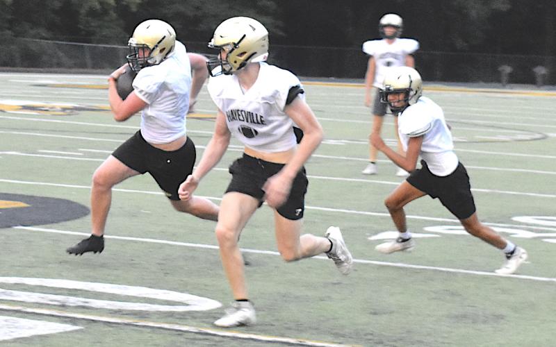 Johan Webb motors down field with blockers Logan Querns and Josue Salas during a punt return drill last week.